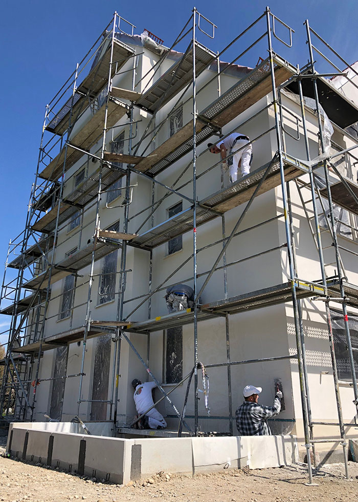 Arbeiter beim Verputzen von Hausfassade